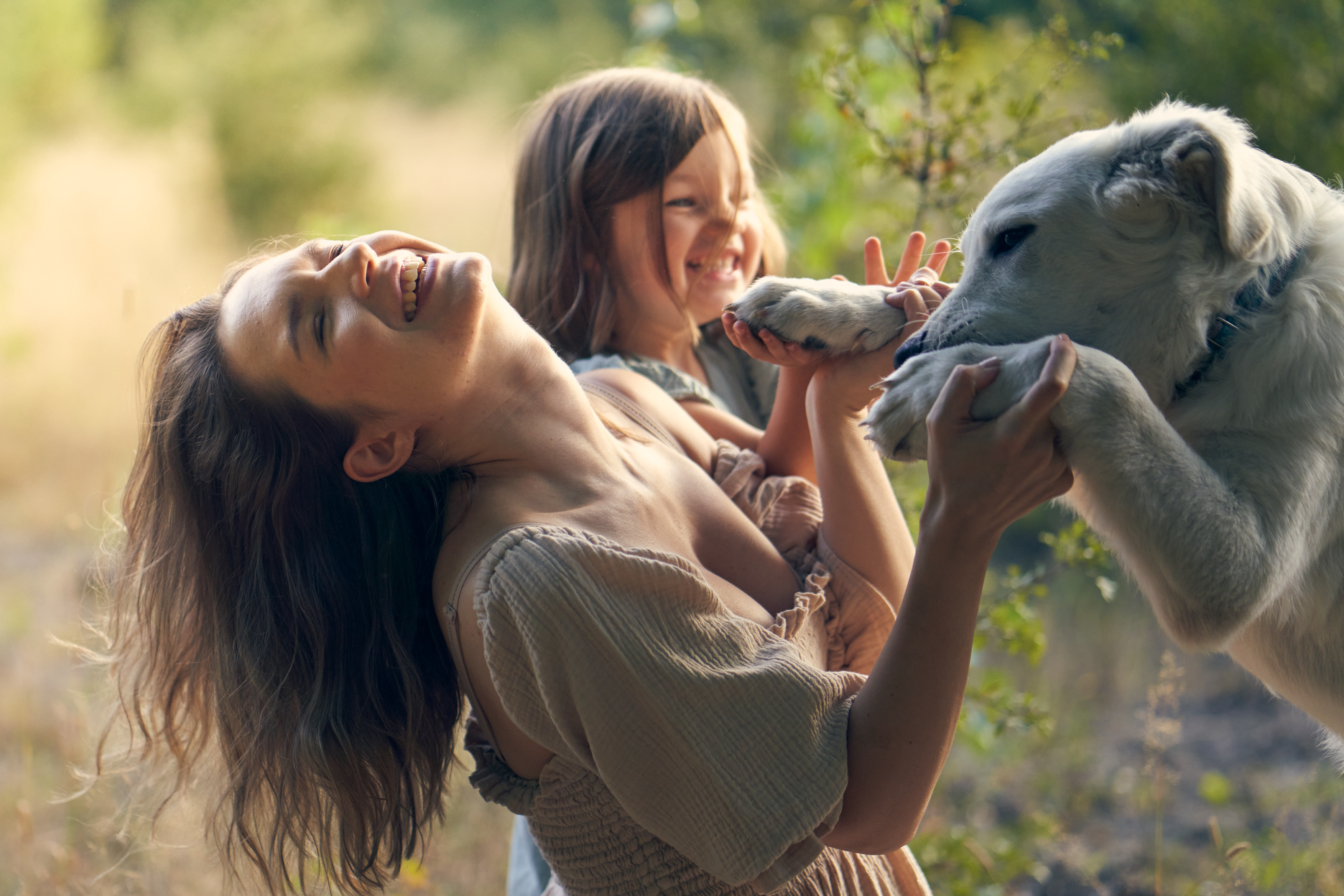 Mama z córką i psem podczas rodzinnej sesji w ciepłym świetle